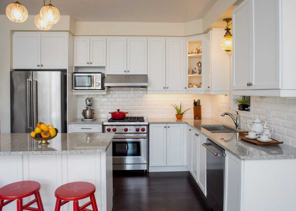 Kitchen with white cabinets, red accents and stainless steel appliances